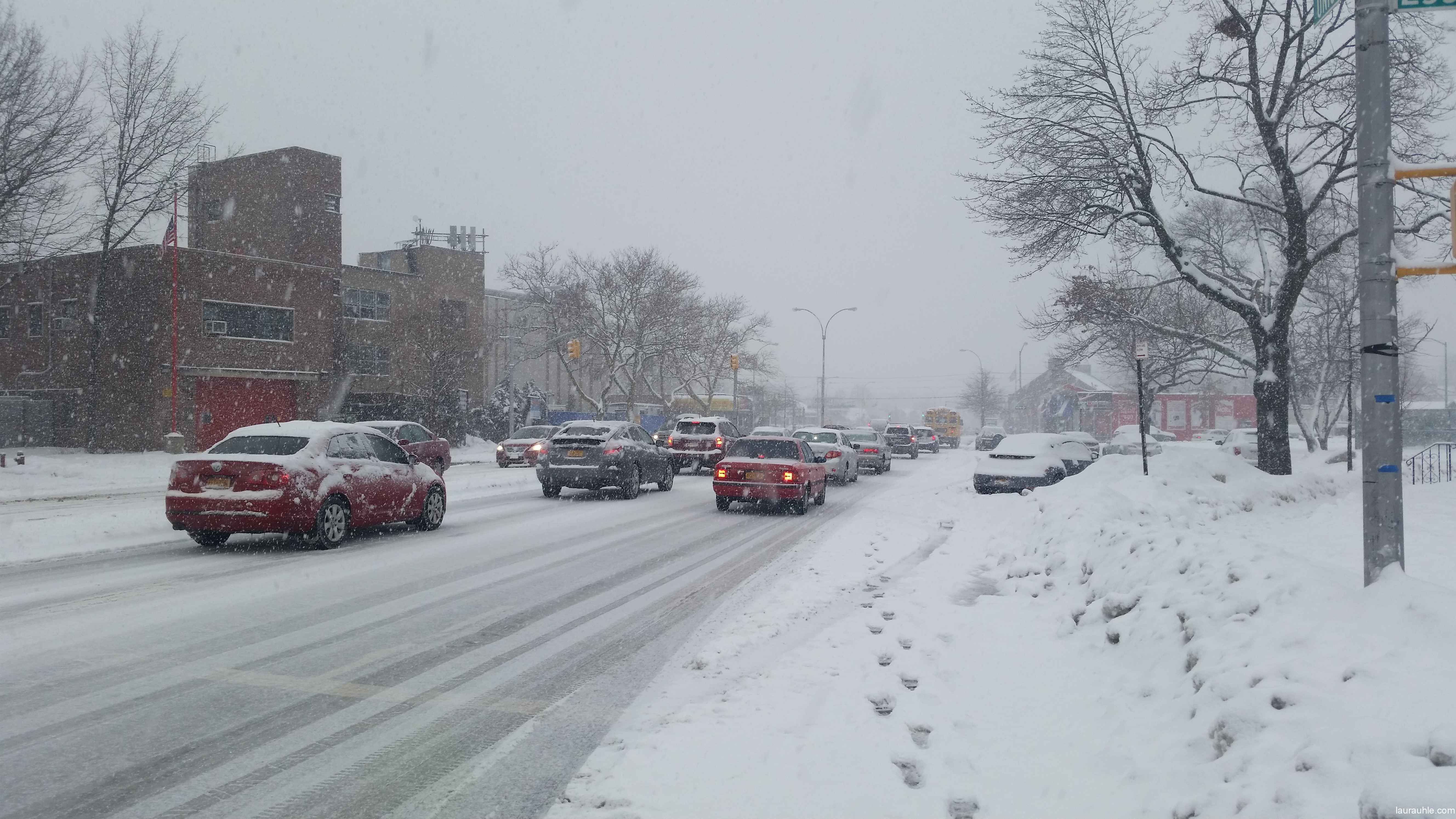 Traffic in the snow on Union Turnpike across the fire station.